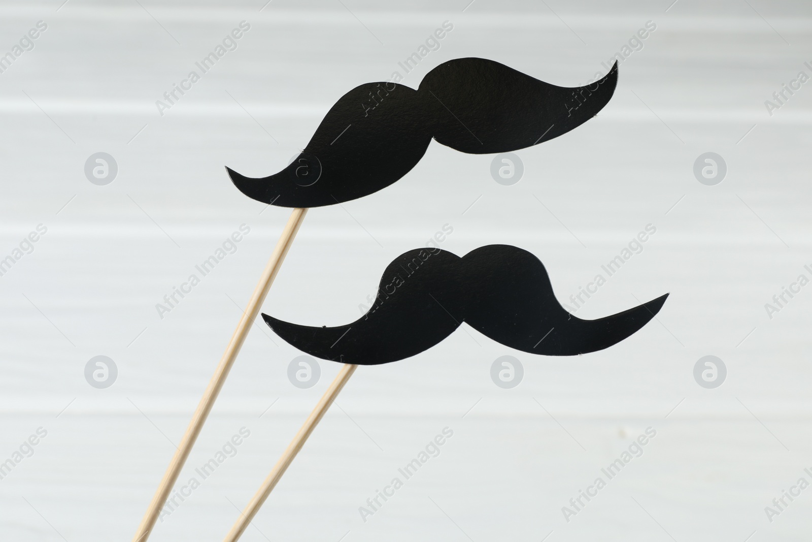 Photo of Fake paper mustaches party props on white background