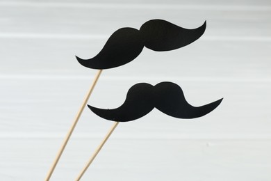 Photo of Fake paper mustaches party props on white background