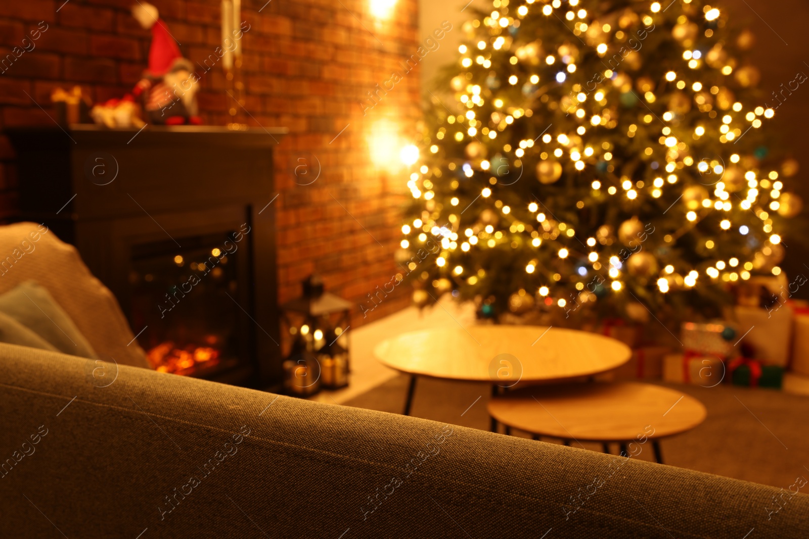 Photo of Blurred view of beautiful Christmas tree with lights in living room