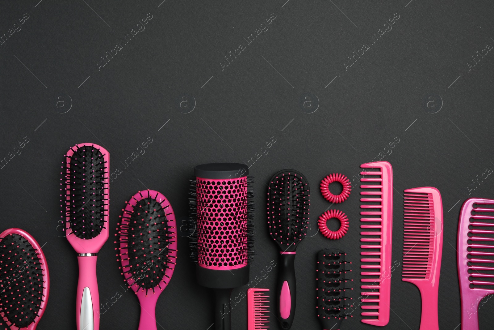 Photo of Flat lay composition with modern hair combs and brushes on black background