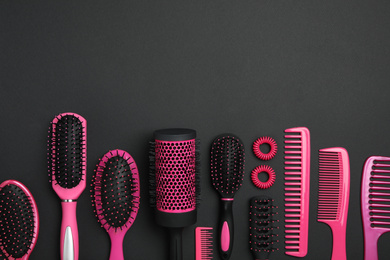 Flat lay composition with modern hair combs and brushes on black background