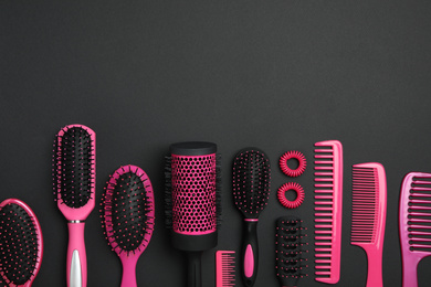 Photo of Flat lay composition with modern hair combs and brushes on black background