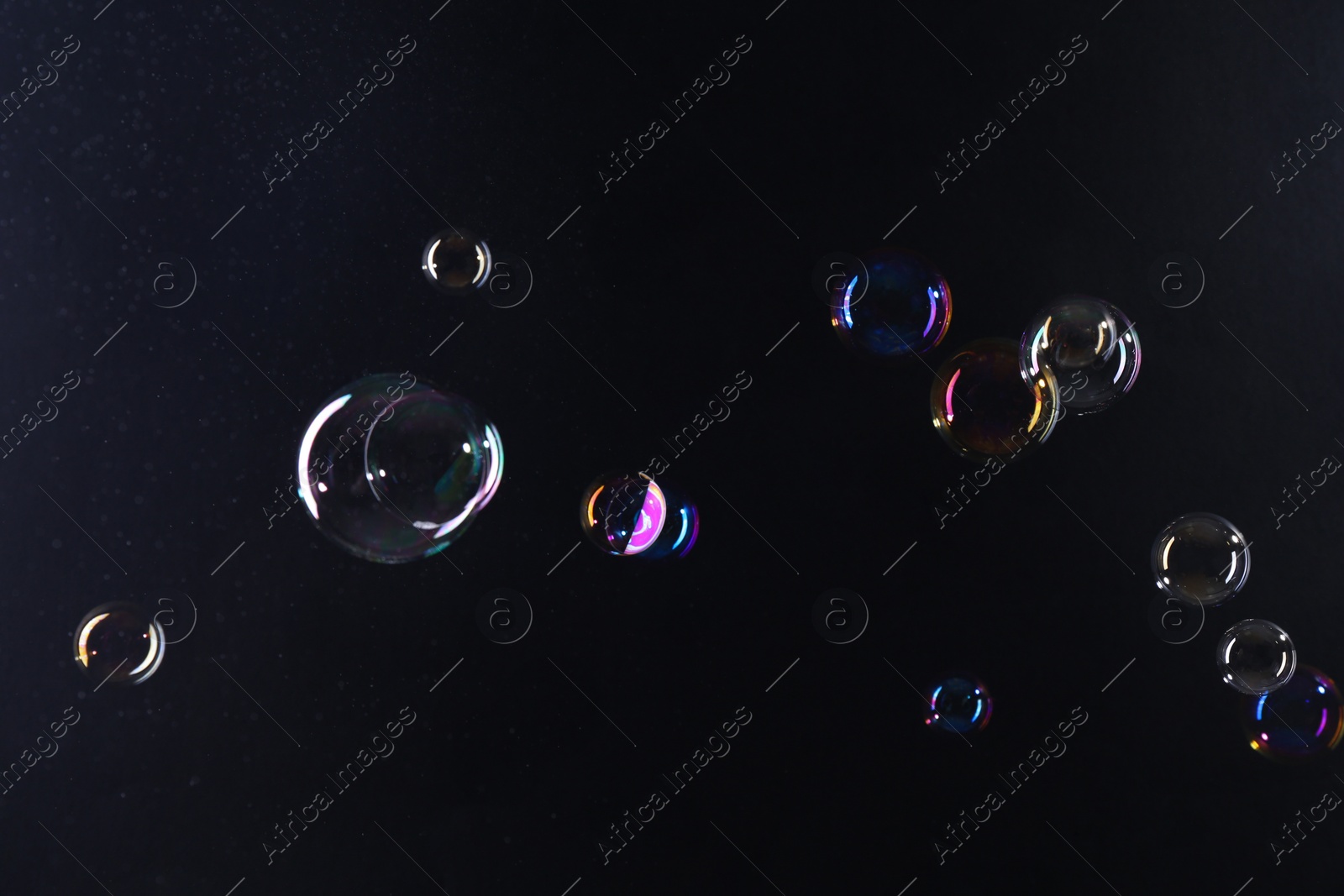 Photo of Beautiful transparent soap bubbles on dark background