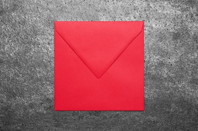 Red envelope on grey table, top view