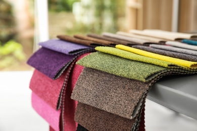 Photo of Fabric samples of different colors for interior design on table