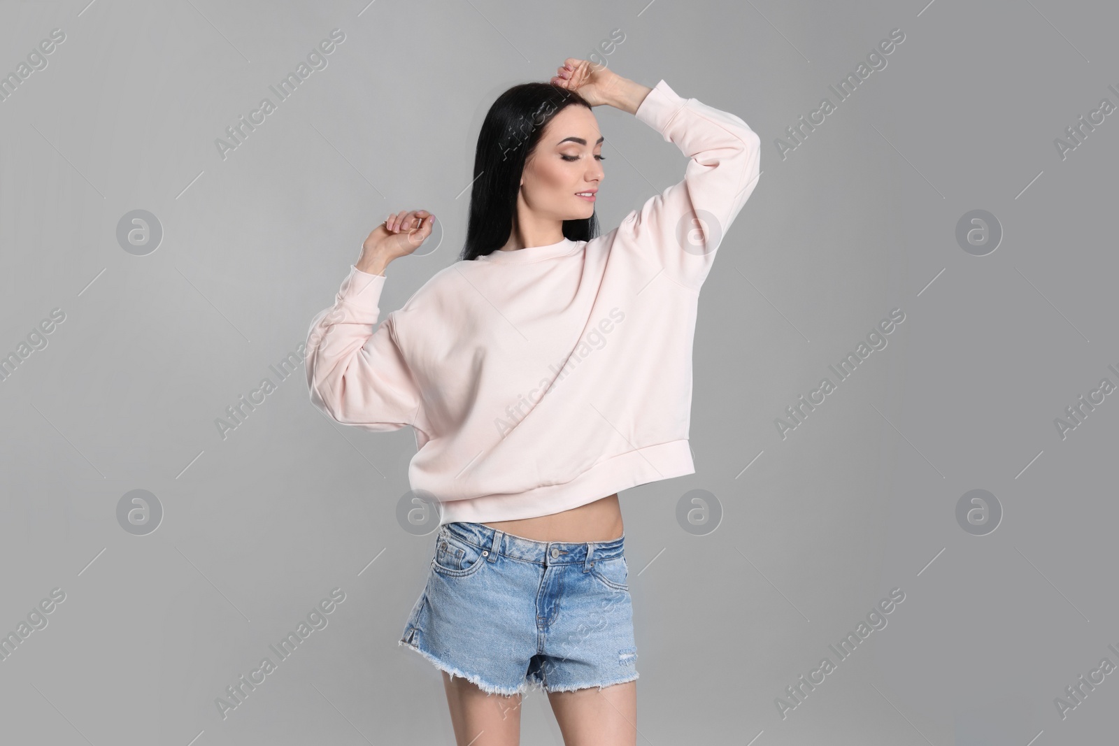 Photo of Portrait of young woman in sweater on grey background. Mock up for design