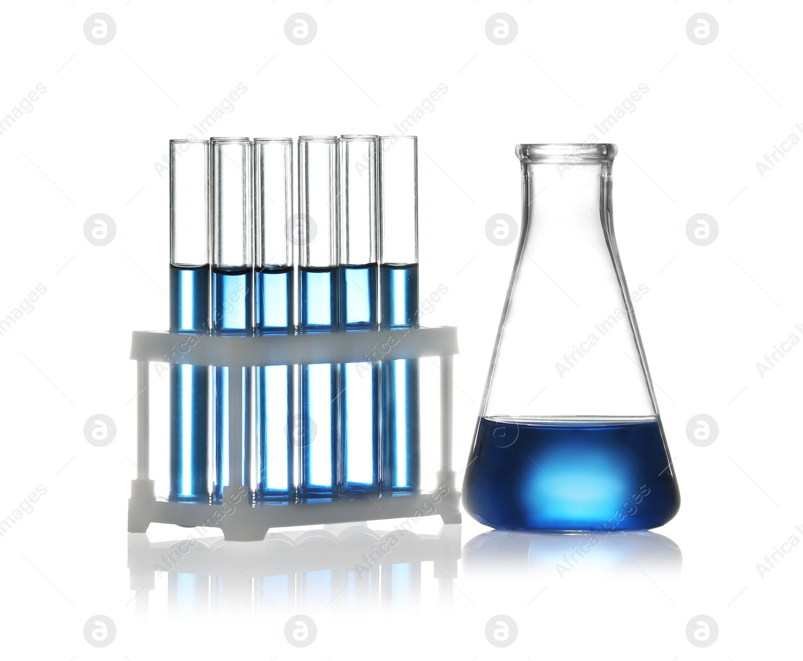 Photo of Test tubes in rack and conical flask with liquid samples on white background. Chemistry glassware