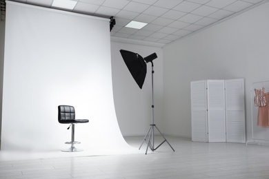 Photo of Photo studio interior with modern chair and professional lighting equipment