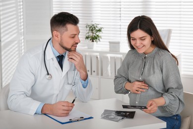 Photo of Pregnant woman with ultrasound picture at doctor's appointment in clinic