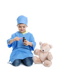 Photo of Cute child playing doctor with stuffed toy on white background