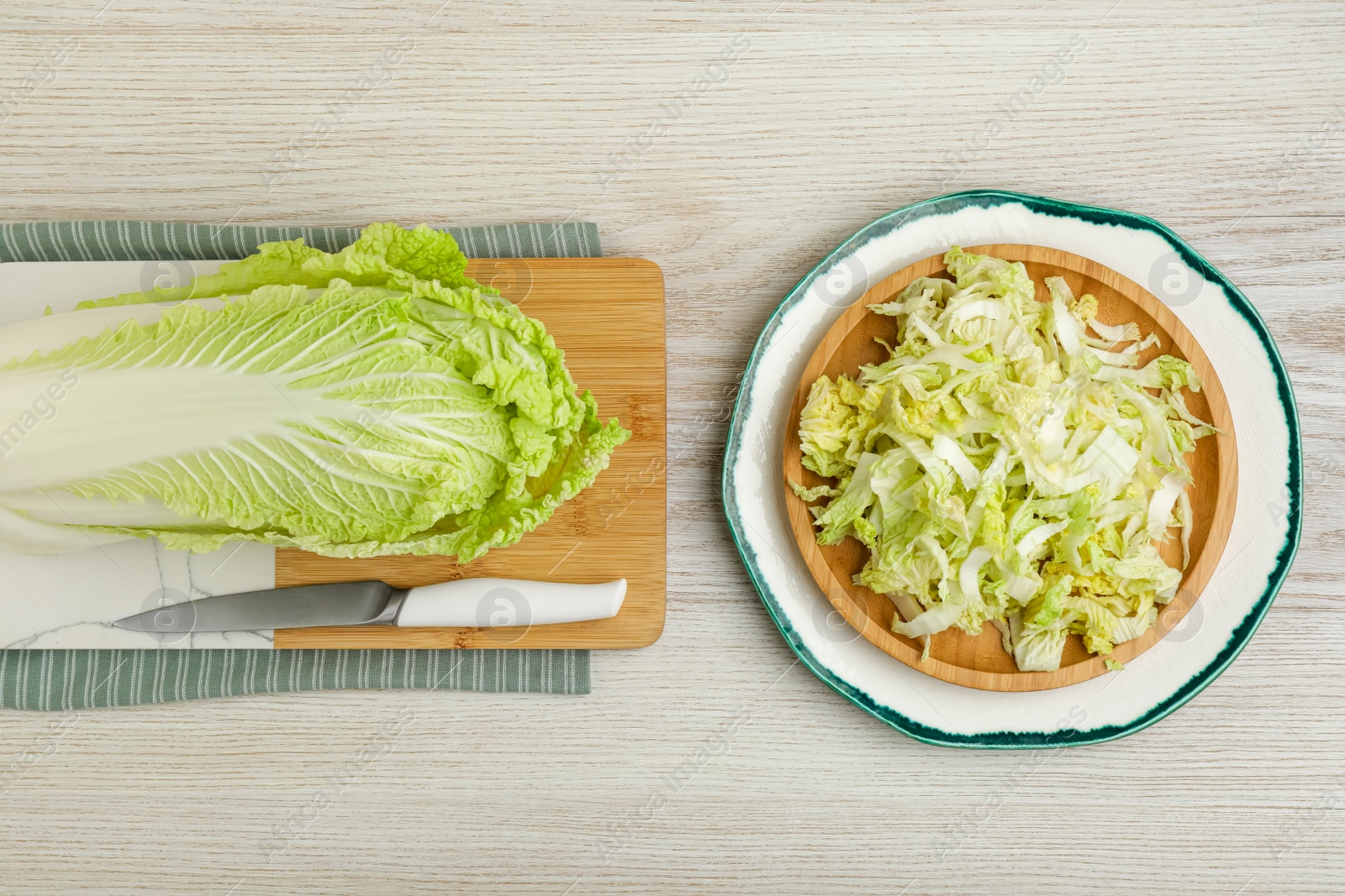 Photo of Whole and cut fresh ripe Chinese cabbage on white wooden table, flat lay