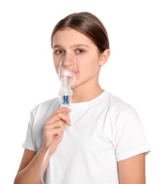 Cute girl using nebulizer for inhalation on white background