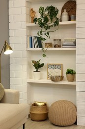 Photo of Beautiful green plants and different decor on shelves indoors. Interior design