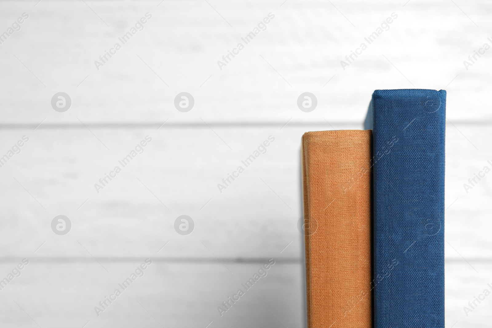 Photo of Old books on white wooden background, space for text