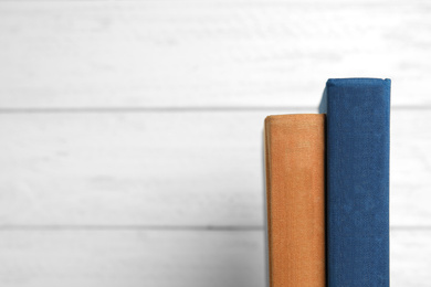 Old books on white wooden background, space for text