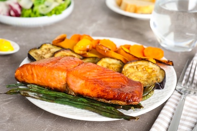 Photo of Delicious cooked salmon and vegetables on grey table, closeup. Healthy meals from air fryer