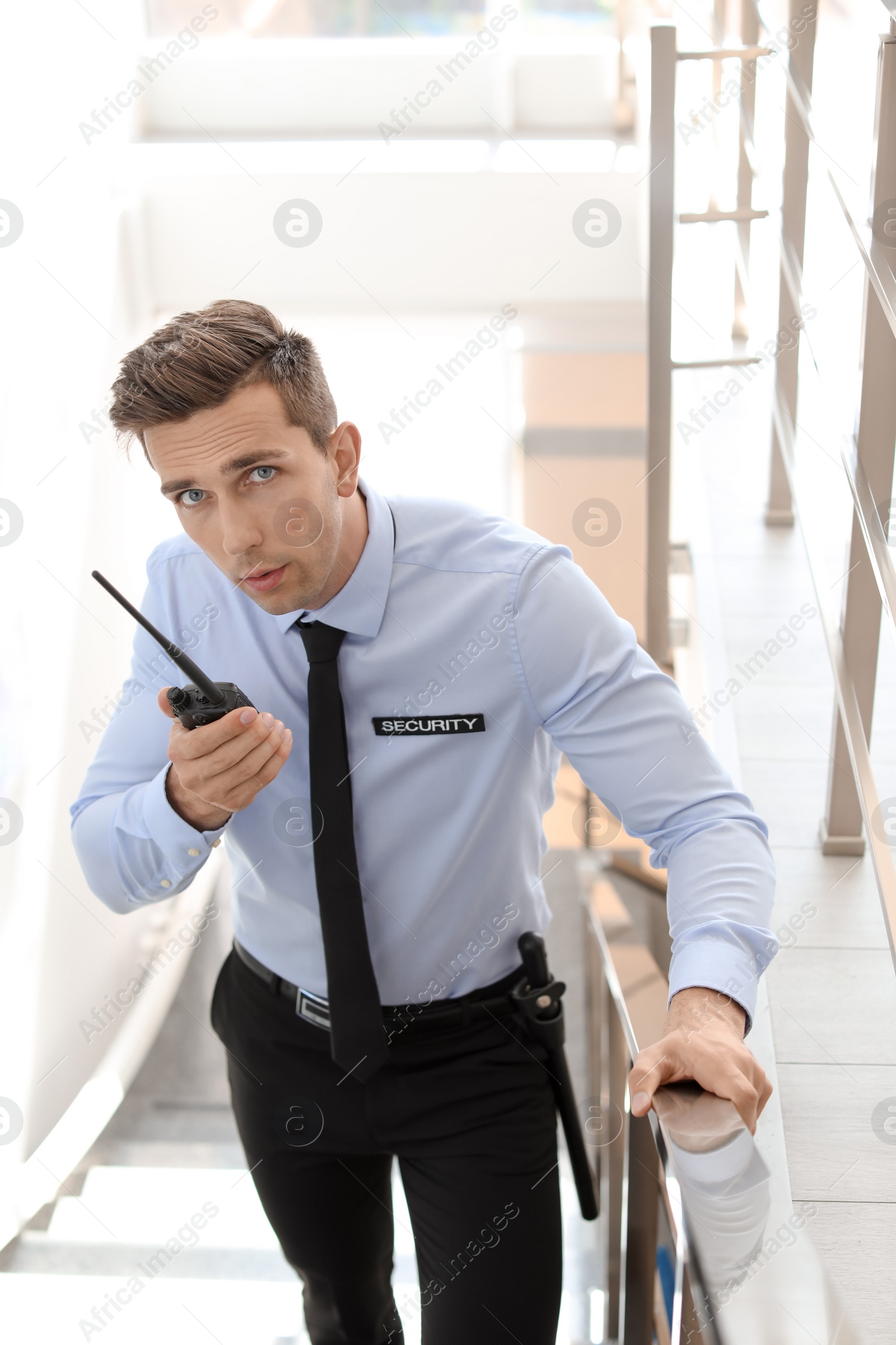 Photo of Male security guard with portable radio transmitter indoors