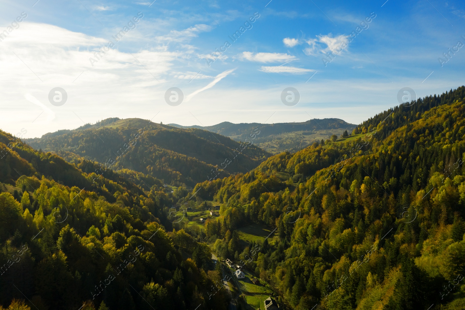 Image of Aerial view of beautiful mountain forest and village on autumn day