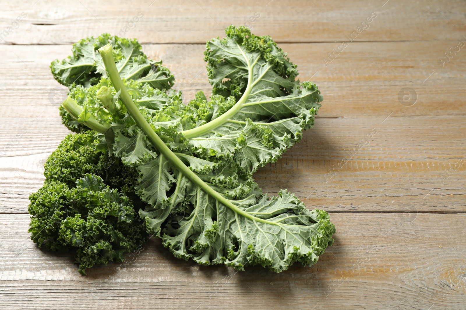 Photo of Fresh green kale leaves on wooden table