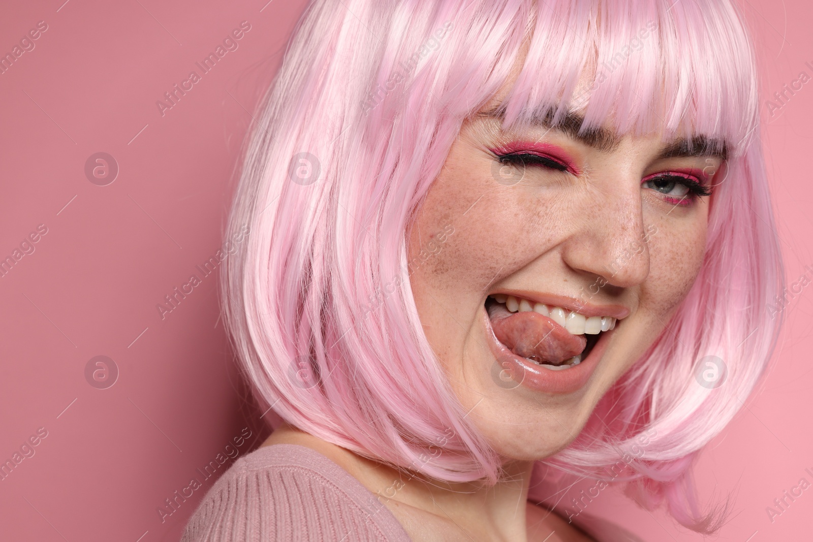 Photo of Happy woman with bright makeup and fake freckles on pink background, closeup