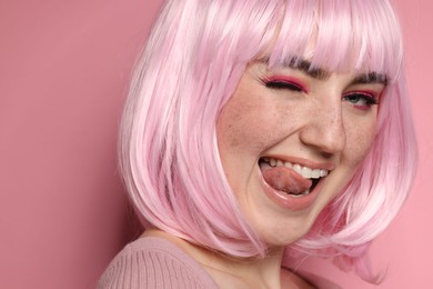 Happy woman with bright makeup and fake freckles on pink background, closeup