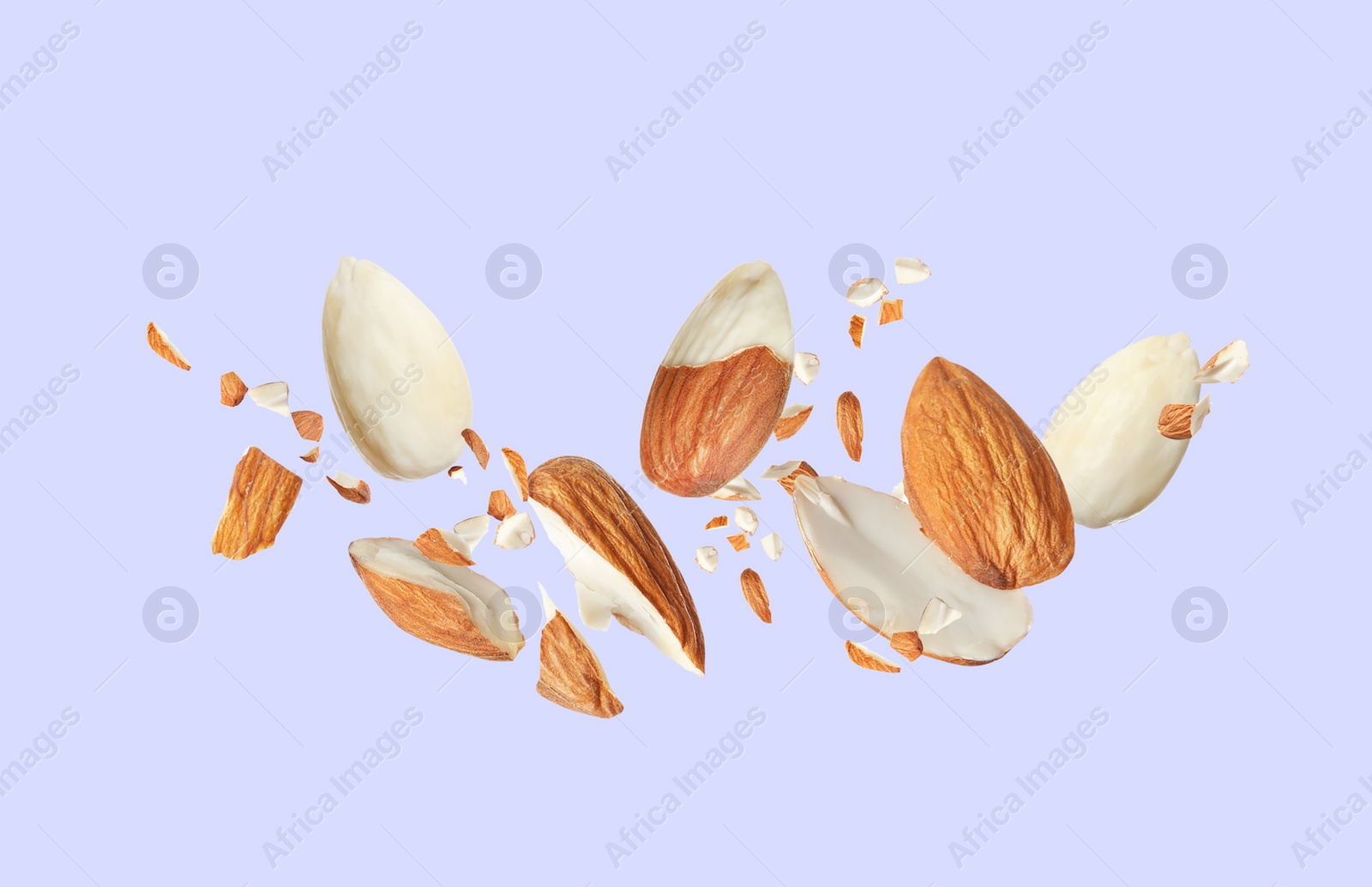 Image of Pieces of tasty almonds falling on light grey background