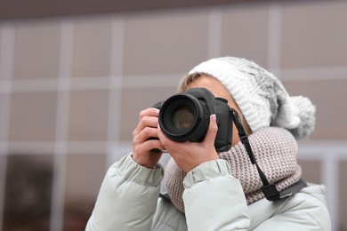 Photographer taking photo with professional camera outdoors. Space for text