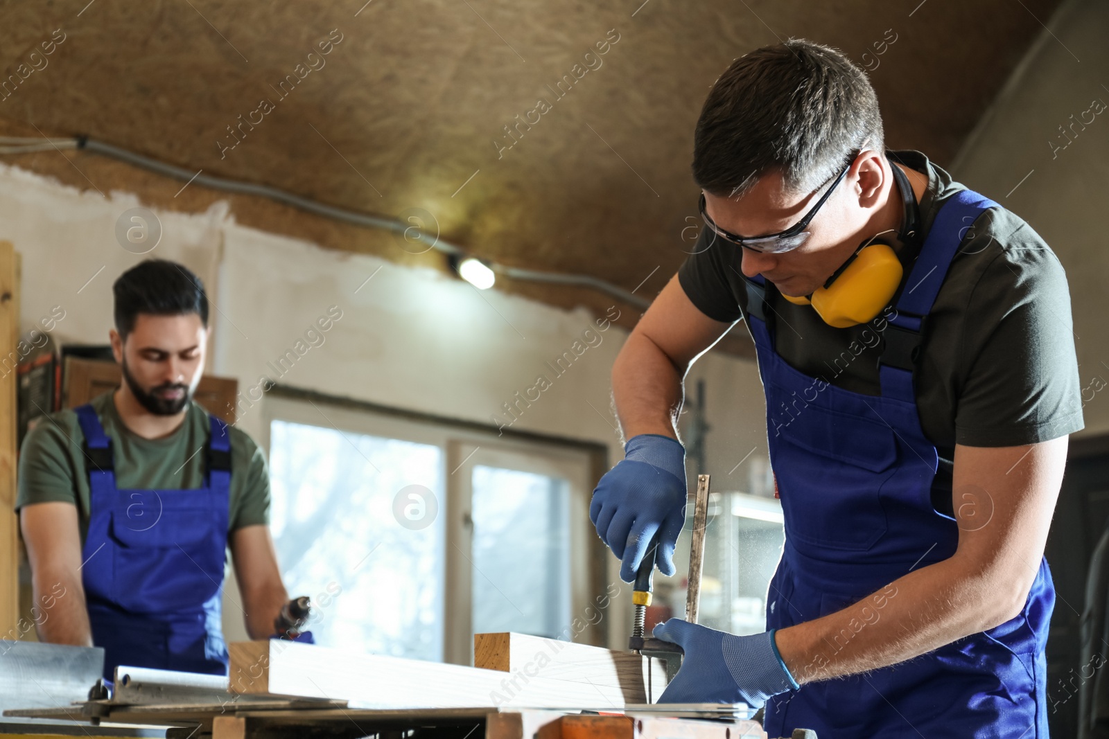 Photo of Professional carpenters working with wood in shop