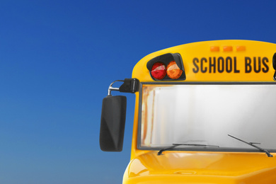 Image of Yellow school bus on blue background, closeup. Transport for students