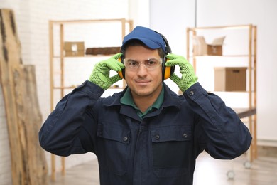 Worker wearing safety headphones indoors. Hearing protection device