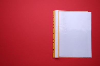 Photo of File folder with punched pockets and paper sheets on red background, top view. Space for text