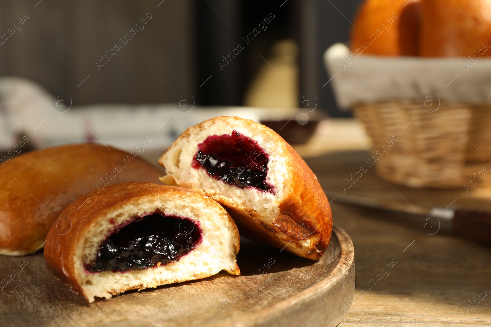 Photo of Delicious baked patties with jam on wooden table, closeup