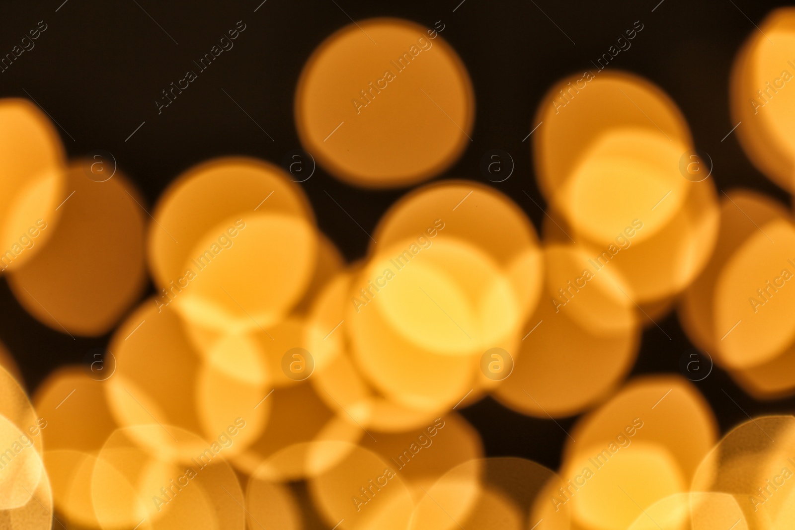 Photo of Beautiful golden lights on dark background. Bokeh effect