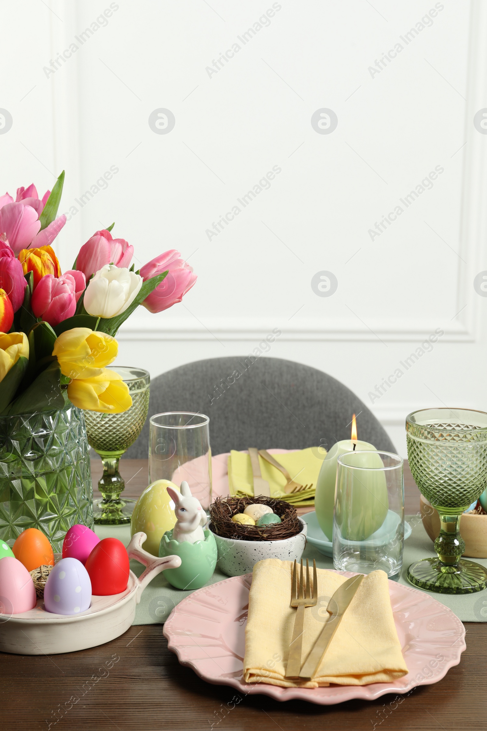 Photo of Easter celebration. Festive table setting with beautiful flowers and painted eggs