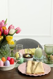 Easter celebration. Festive table setting with beautiful flowers and painted eggs