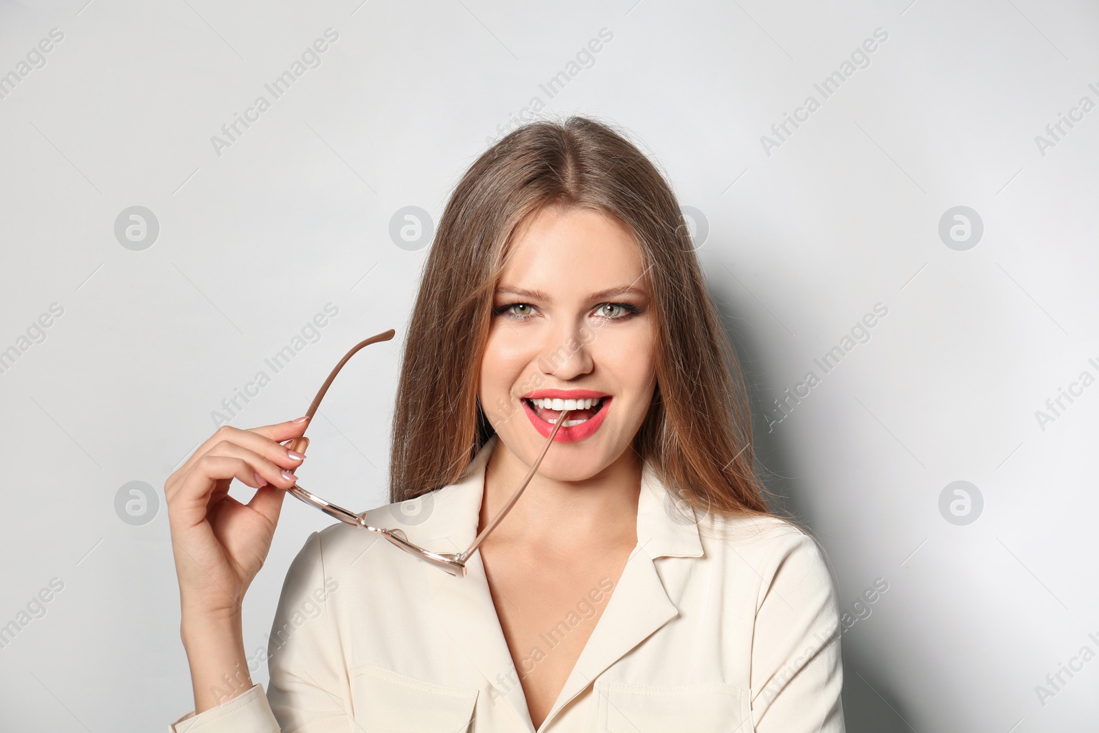 Photo of Young woman with stylish sunglasses on light background