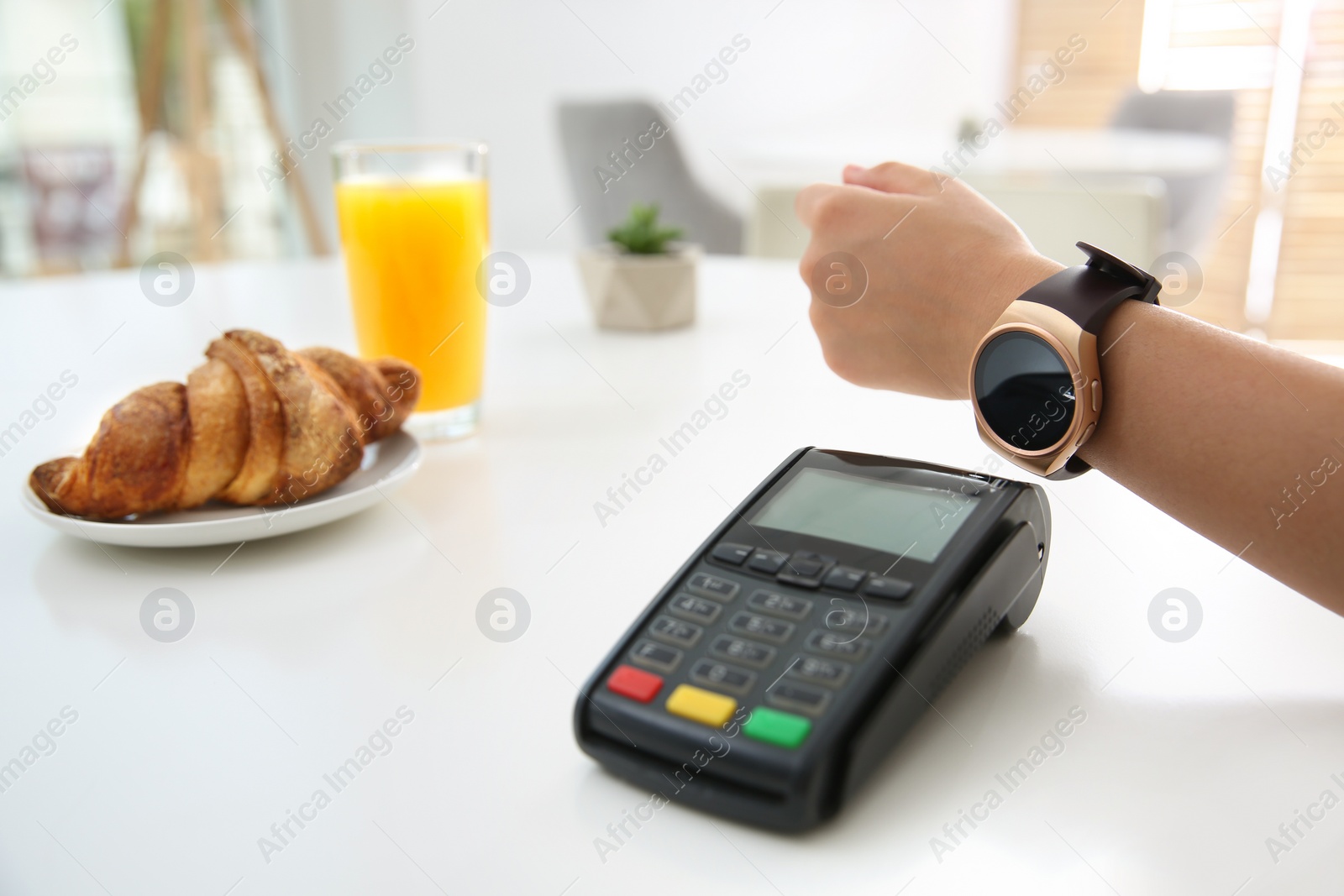 Photo of Woman using smart watch for contactless payment via terminal in cafe, closeup