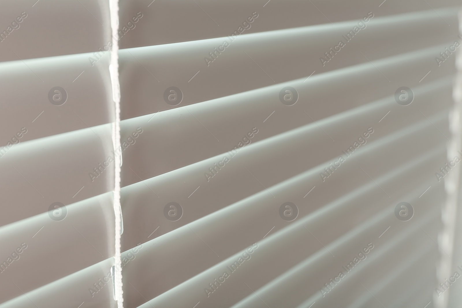 Photo of Closed modern white window blinds, closeup view