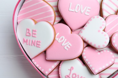 Photo of Delicious heart shaped cookies in box on white table, closeup. Valentine's Day