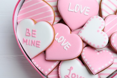 Delicious heart shaped cookies in box on white table, closeup. Valentine's Day