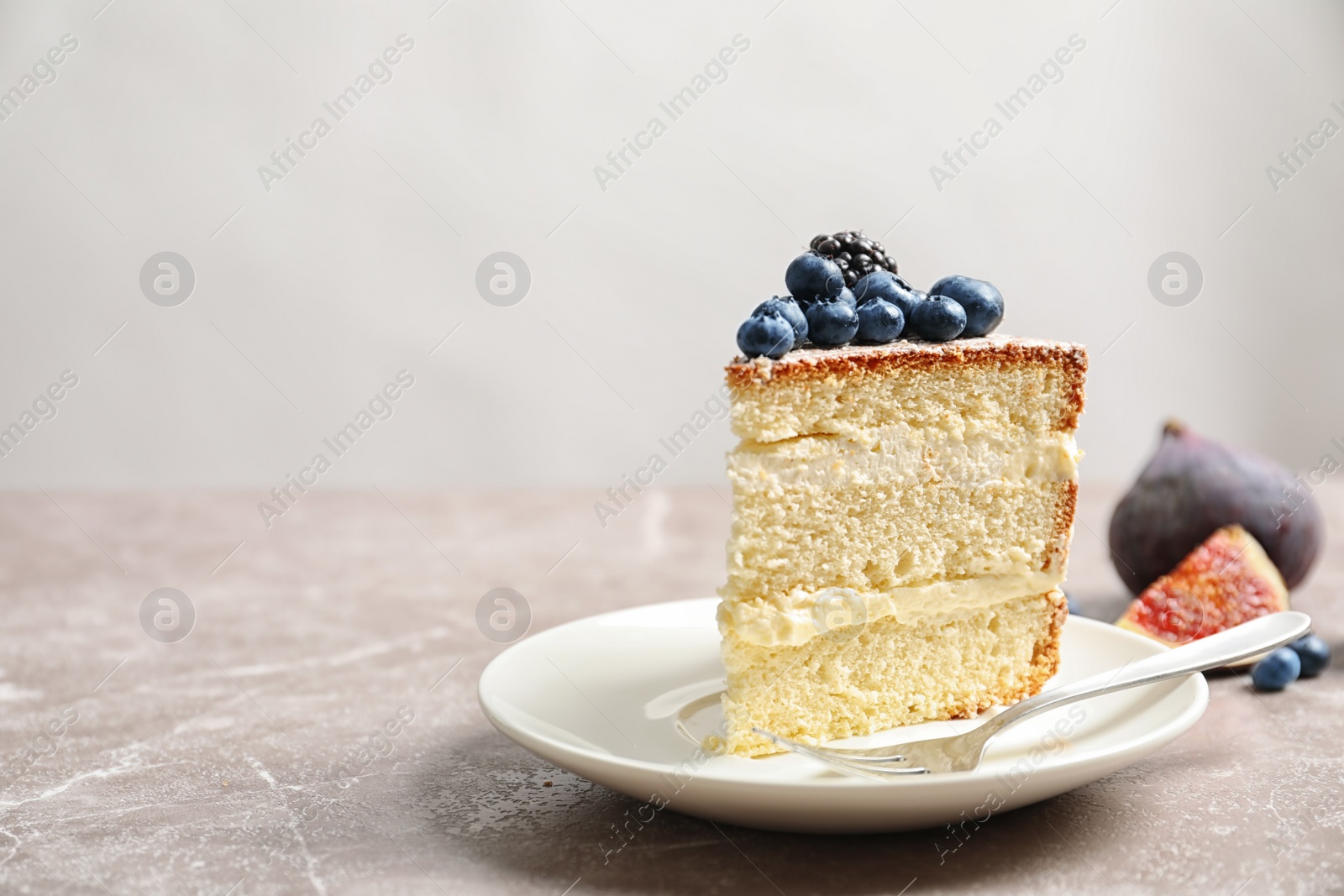 Photo of Piece of delicious homemade cake with fresh berries and space for text on light background