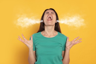 Aggressive woman with steam coming out of her ears on orange background