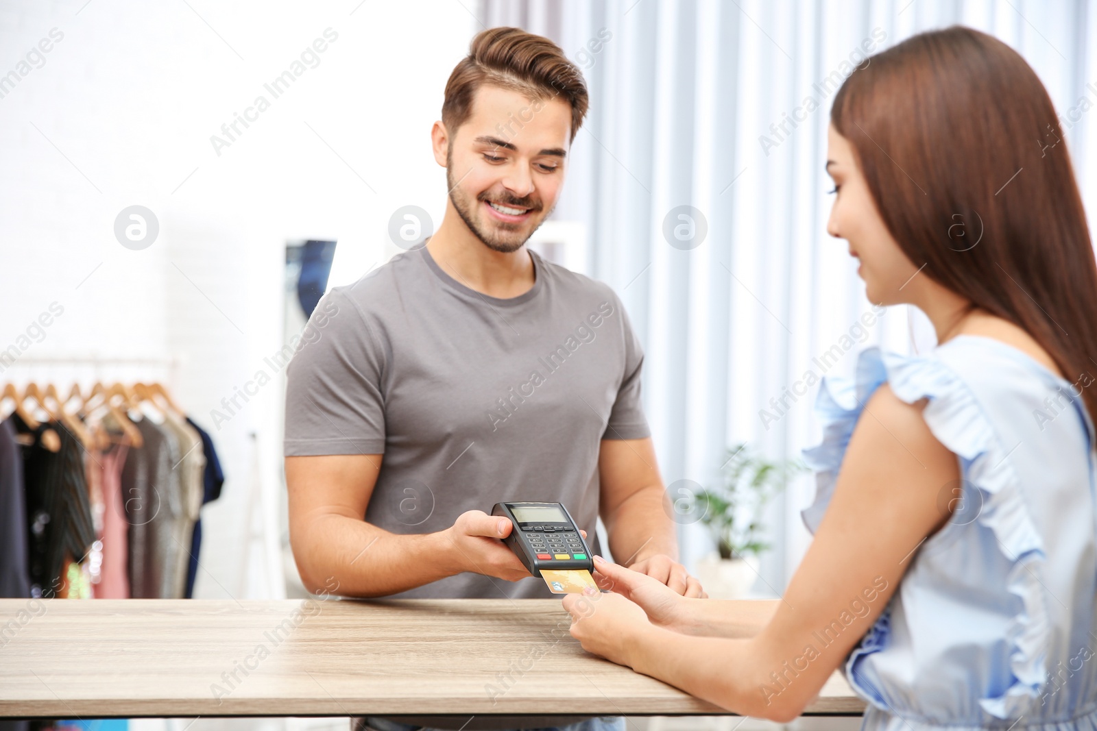 Photo of Woman using terminal for credit card payment in shop