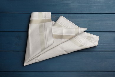 Stylish handkerchief on blue wooden table, top view