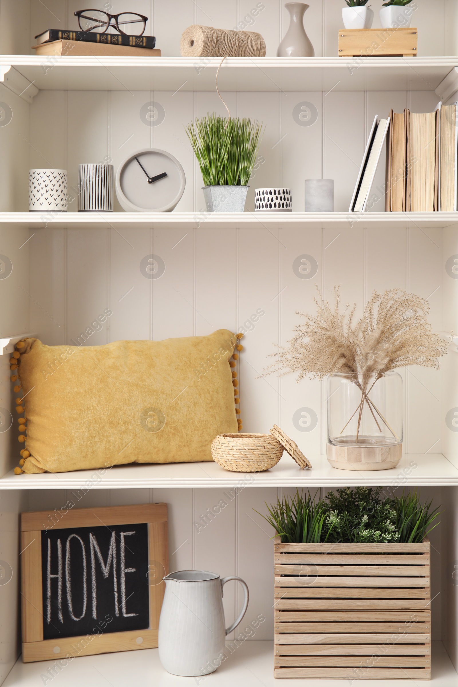 Photo of White shelving unit with plants and different decorative stuff