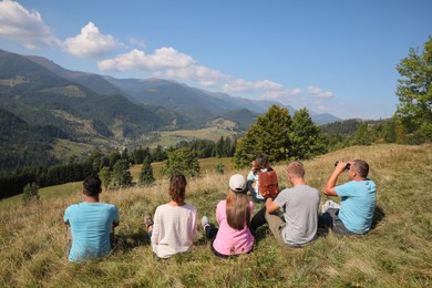 Photo of Grouppeople spending time together in mountains, back view