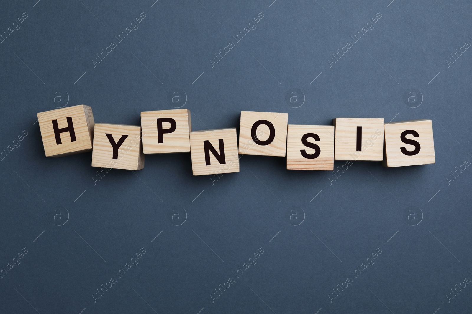 Photo of Wooden blocks with word HYPNOSIS on dark background, flat lay