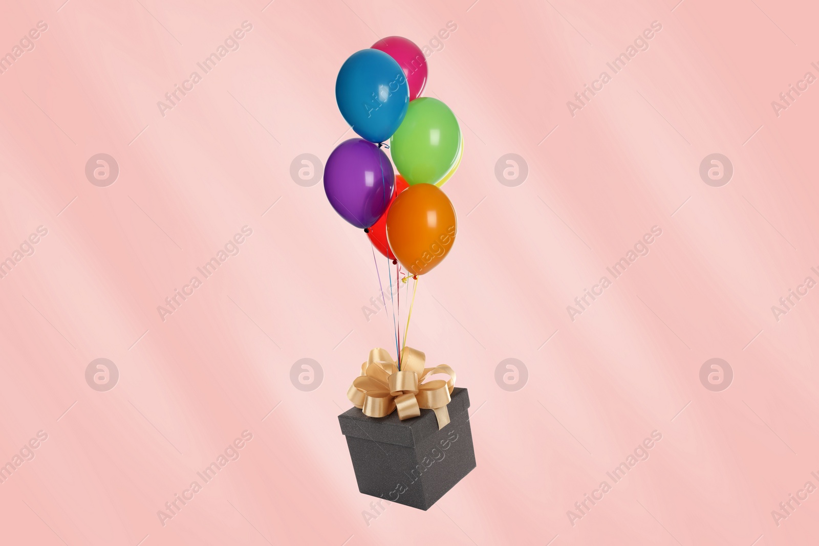Image of Many balloons tied to gift box on pink background