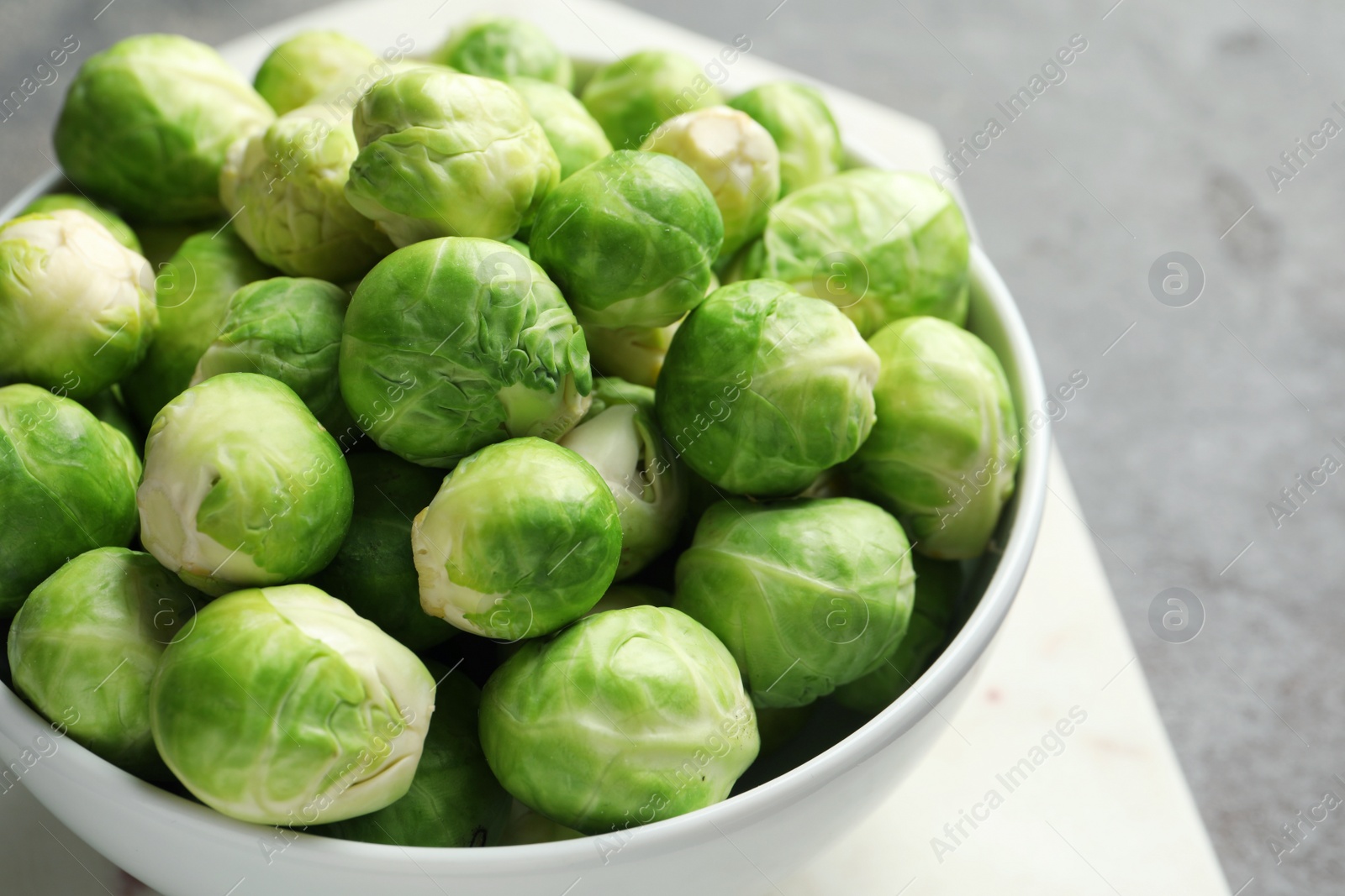 Photo of Bowl of Brussels sprouts on table, closeup. Space for text