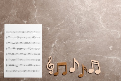 Sheet and music notes on color background, top view. Space for text